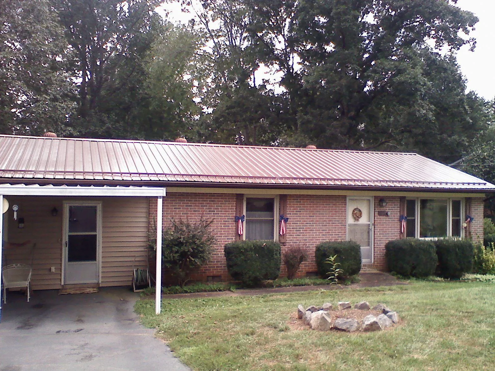 Bronze metal roof and carport on a brick ranch home — Roof Repair work by our crew in Chincoteague Island